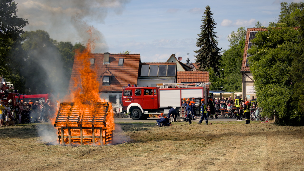 Die Jugendfeuerwehr rückt an, um das brennende Holzhaus zu löschen Die Jugendfeuerwehr rückt an, um das brennende Holzhaus zu löschen